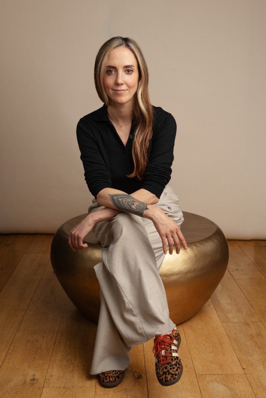 Samantha Whittaker, psychotherapist, seated on a gold stool